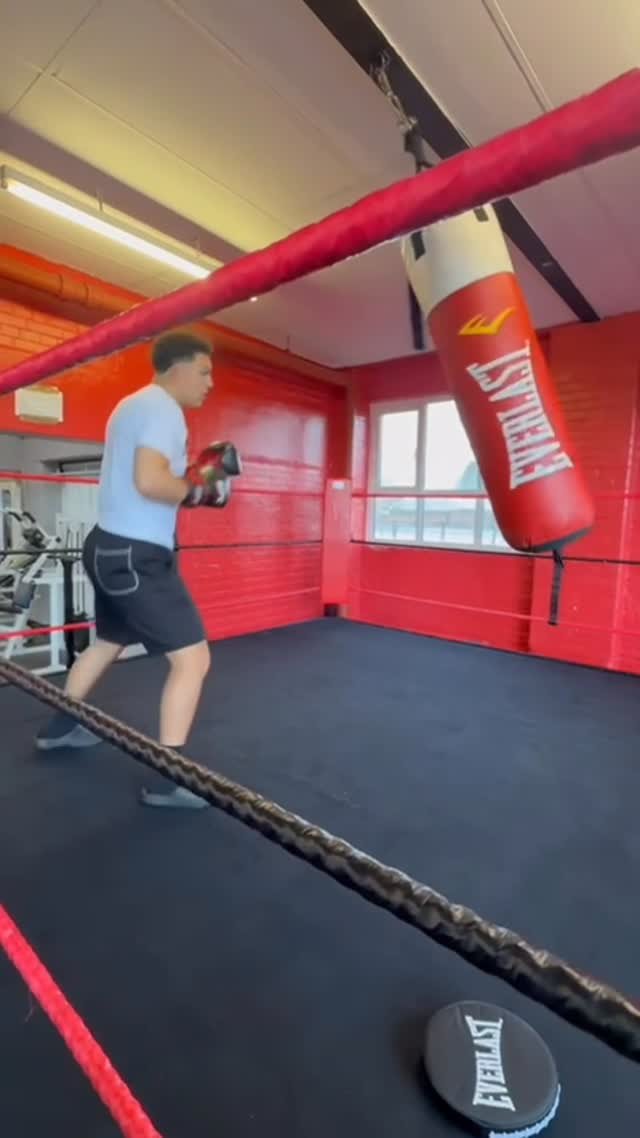 The new boxing ring with red ropes on the gym floor
