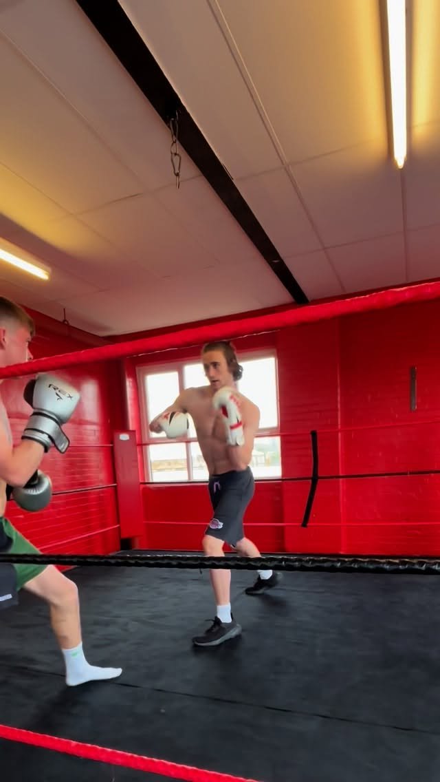 Two people sparring inside the boxing ring