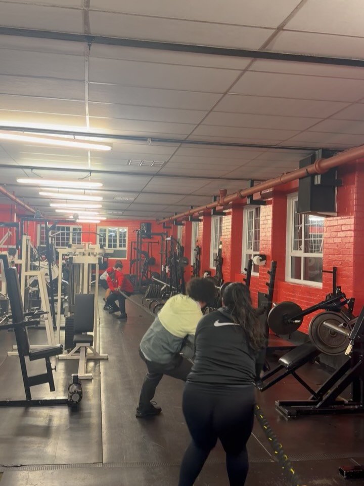 The long training floor at Winners Gym, with red brick walls and rows of machines
