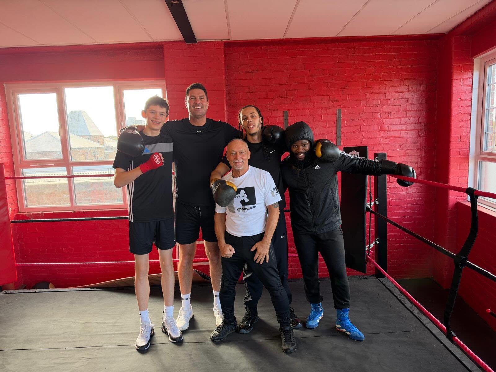 A group of visitors in the red room beside the boxing ring